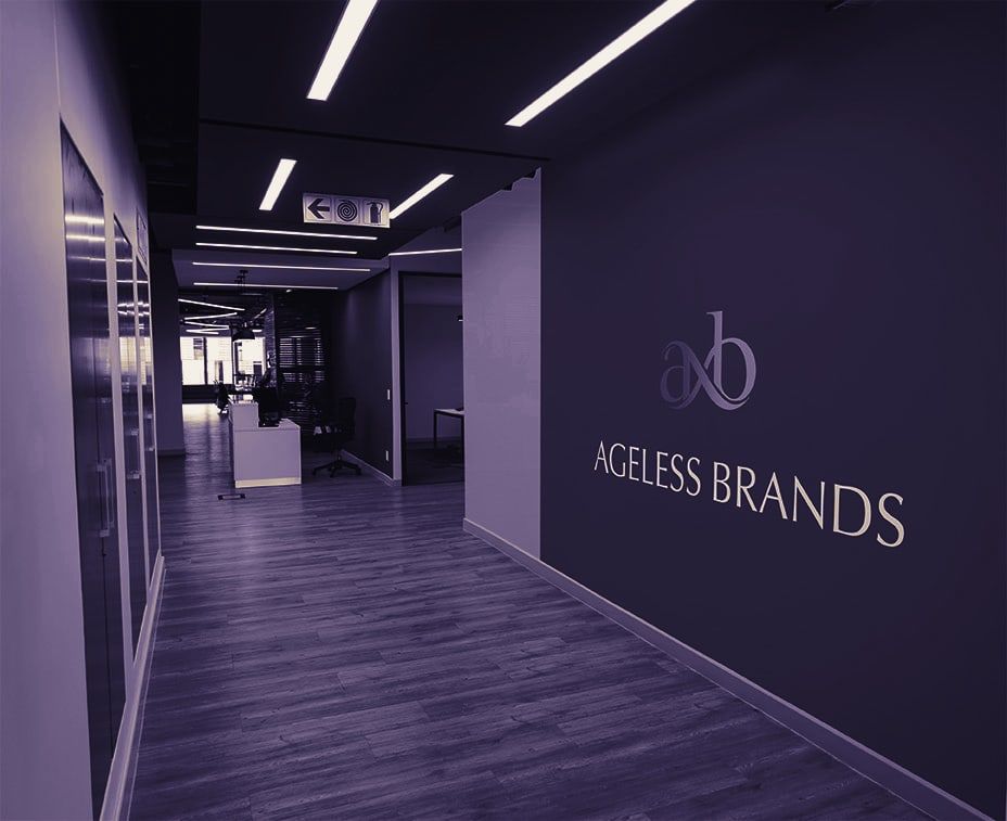 An office corridor with the Ageless Brands axb mark on the wall